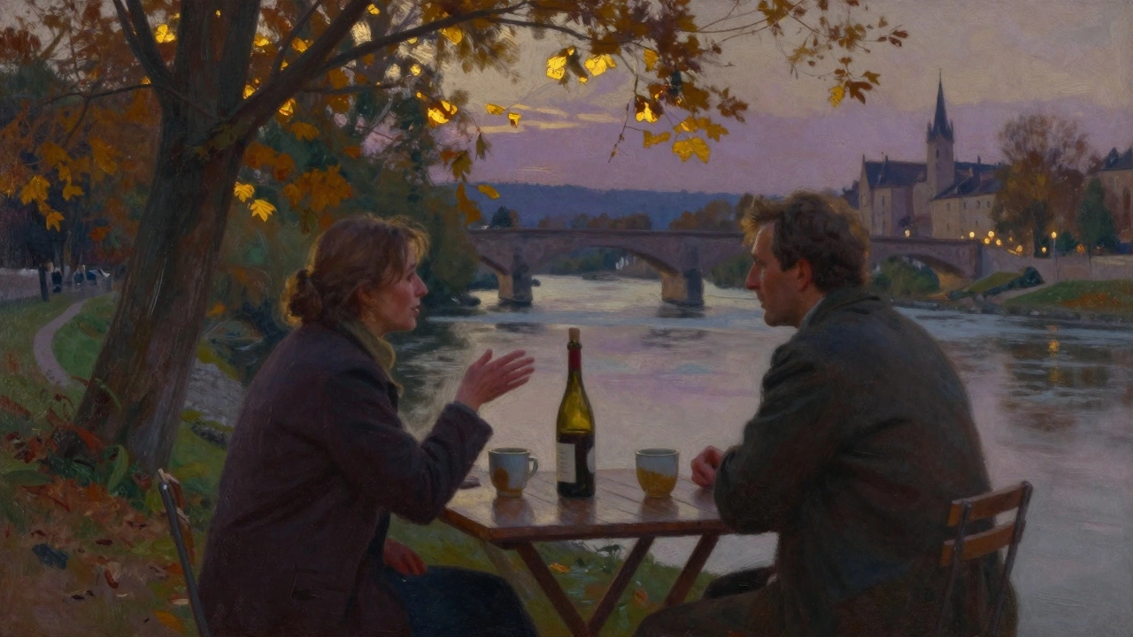 Two people share wine by a river at dusk in Grenoble, golden light filtering through trees, silent and intimate.